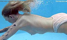 MIMI,一个有纹身的年轻女孩,在游泳池里裸体游泳